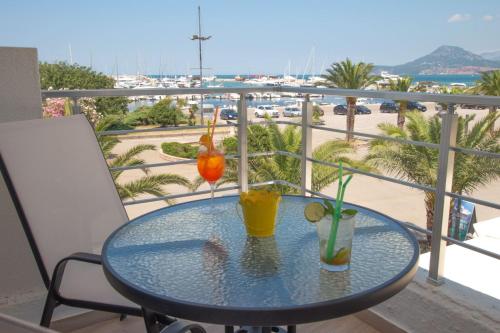 a glass table with two drinks on a balcony at Apartmani Port in Bar