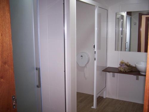 a bathroom with a glass shower with a sink at Albergue San Pedro in Corcubión