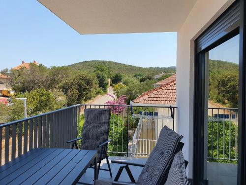 a balcony with a table and two chairs and a view at Apartmani Nerium in Lovište
