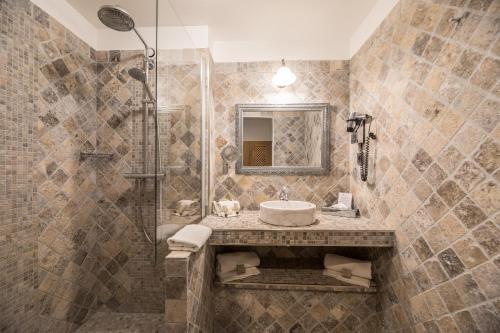 a bathroom with a sink and a shower at Hôtel Le Roi Théodore & Spa in Porto-Vecchio