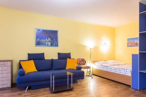a living room with a blue couch and a bed at Nauky avenue in Kharkiv