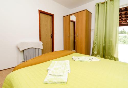 a bedroom with a bed with two towels on it at Guest House Kola in Slano