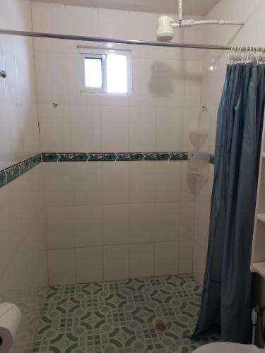 a bathroom with a shower with a blue shower curtain at Urania House in Bocas del Toro