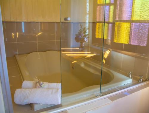 y baño con bañera y toalla. en Villa da Vila, en Monte Verde