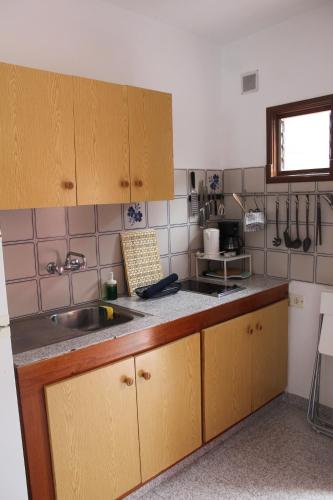 a kitchen with wooden cabinets and a sink at ApartamentosPlaya_Hermigua in Hermigua