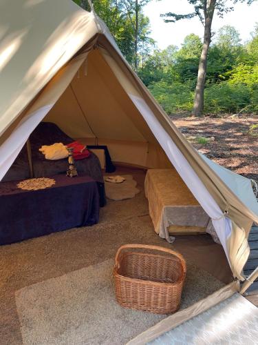 a tent with a bed and a basket in it at Naturglamping in Kristianstad