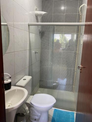 a bathroom with a shower and a toilet and a sink at Mellim Residence in Maragogi