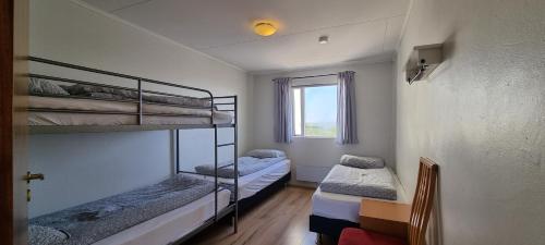 two bunk beds in a room with a window at Hítarneskot Holiday Home in Hítarneskot