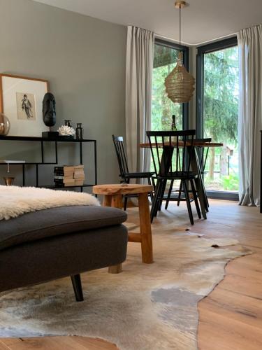 sala de estar con cama, mesa y sillas en Bungalow im Wald, en Borkwalde