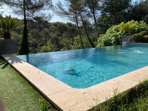 une piscine avec de l'eau bleue dans une cour dans l'établissement Maison ensoleillée au milieu des pins entre Marseille et Cassis, à Marseille