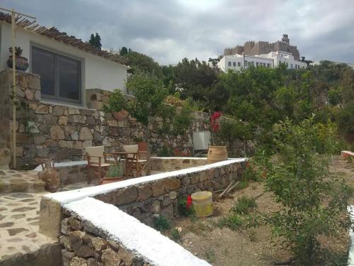 una casa con un muro di pietra di fronte di TRADITIONAL STUDIO Chora Patmos a Patmo (Patmos)