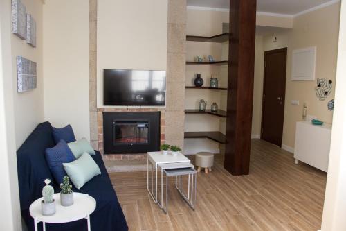 a living room with a blue couch and a fireplace at Templar Spot in Tomar