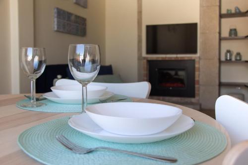 a table with two wine glasses and a white bowl at Templar Spot in Tomar