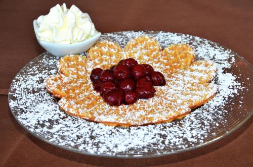 a plate with fruit and whipped cream on a table at velcrea in Willebadessen