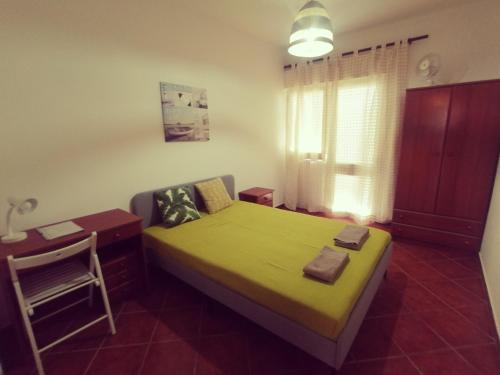 1 dormitorio con 1 cama con silla y escritorio en Apartamento S. Luis, en Faro