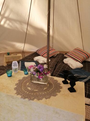 a tent with a table with flowers on it at Naturglamping in Kristianstad