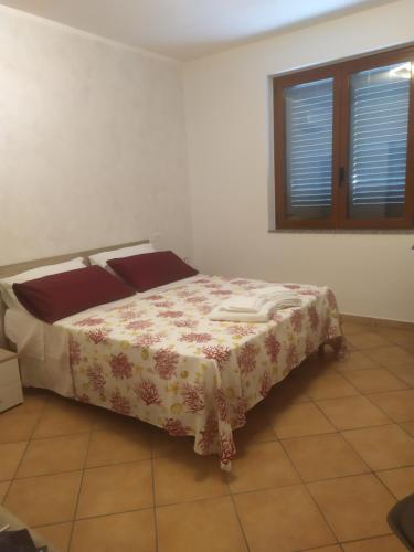 een slaapkamer met een bed met een deken erop bij Nel7 in Castellammare di Velia