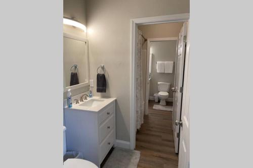 La salle de bains est pourvue d'un lavabo blanc et d'un miroir. dans l'établissement Beach Jewel 5bd-3 1/2 bath -5 min walk to Beach!, à Destin