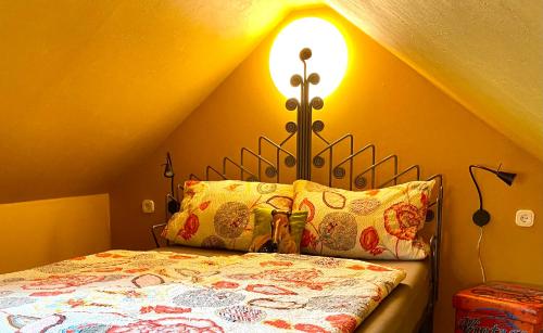 1 dormitorio con 1 cama y una luz en la pared en Maisonette - 2 Schlafzimmer - Wohn-Küche - Balkon - Hohes Venn - Monschau - Eifel - Hunde willkommen beim Hof Vierzehnender - Islandpferde, en Monschau