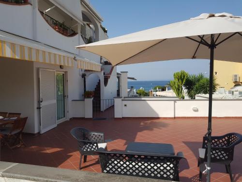 patio con tavolo e ombrellone di LA TERRAZZA DELL^IPPOCAMPO #Seaview apartment a Ischia