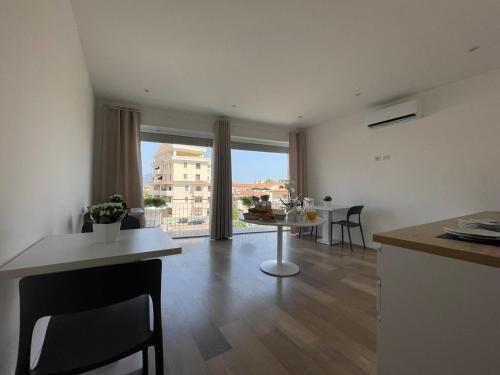 a kitchen and living room with a table and a large window at Nature Room in Olbia