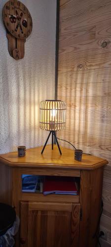 a lamp sitting on top of a wooden table at Très joli studio au calme et bien situé in Orcières