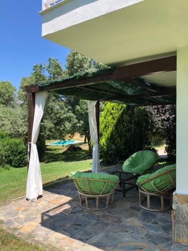 un patio con mesa y sillas bajo toldo en Finca La Fresneda en Sierra de Béjar en Navalmoral de Béjar