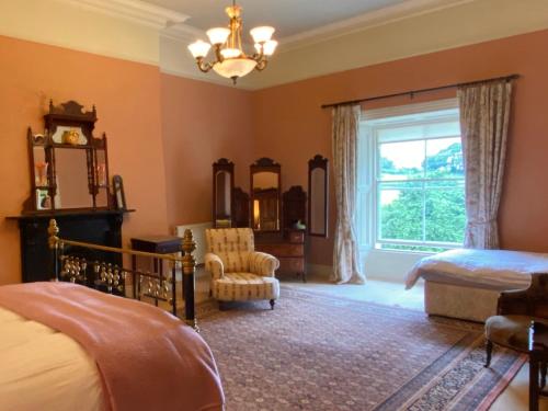 una camera con un letto e una sedia e una finestra di Templemacateer a Contea di Westmeath