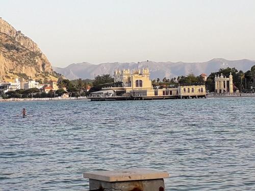ein großes Gebäude inmitten eines Wasserkörpers in der Unterkunft Sicilia vacanze long beach Mondello in Palermo