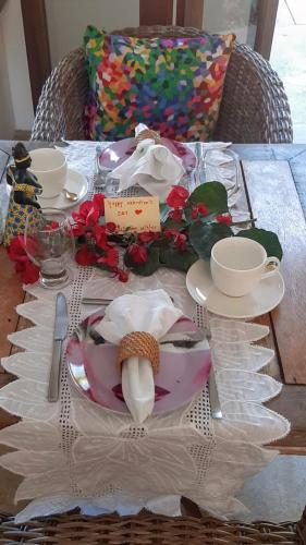 a table with plates and dishes on a table at Guest House Villa 2 Santos in Arraial d'Ajuda