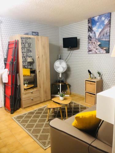 un salon avec un canapé, une table et une télévision dans l'établissement CERES, à Gréoux-les-Bains