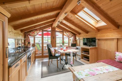 eine Küche und ein Esszimmer mit einem Tisch in einer Hütte in der Unterkunft Landhaus Am Arzbach in Bad Tölz