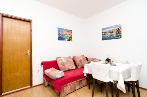 a room with a couch and a table and a table and chairs at Guest House Kola in Slano