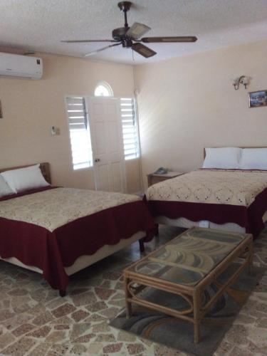 a bedroom with two beds and a ceiling fan at Paradise Inn in Port Antonio