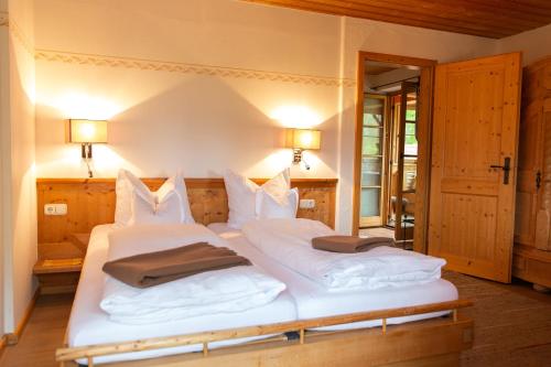 a bedroom with two beds with white pillows at Landhaus Am Arzbach in Bad Tölz