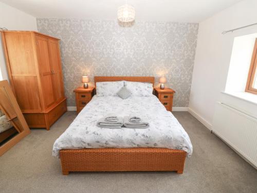 a bedroom with a bed with towels on it at Y Berth Ddu Farmhouse in Caernarfon