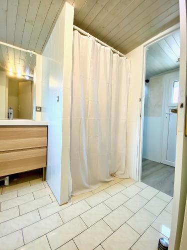 une salle de bain avec un rideau de douche et un lavabo dans l'établissement Arkas YourHostHelper, à Périers-sur-le-Dan