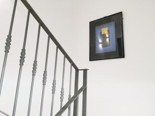 a picture hanging on a wall next to stairs at Apartamentos Tres Llaves Palacio de Vela de los Cobos in Úbeda