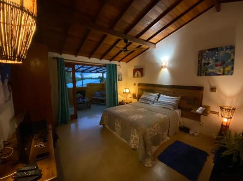 1 dormitorio con 1 cama y sala de estar en Guest House Villa 2 Santos, en Arraial d'Ajuda