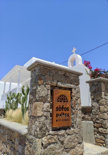 a sign on a stone wall in front of a building at Sofos Suites Mykonos in Mýkonos City
