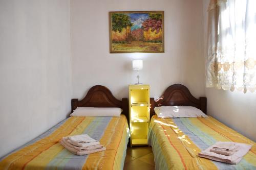 a bedroom with two beds with towels on them at Estancia Santa Leocadia in Bialet Massé