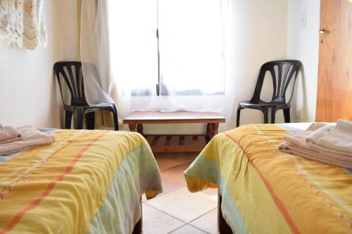 a bedroom with two beds and a table and chairs at Estancia Santa Leocadia in Bialet Massé