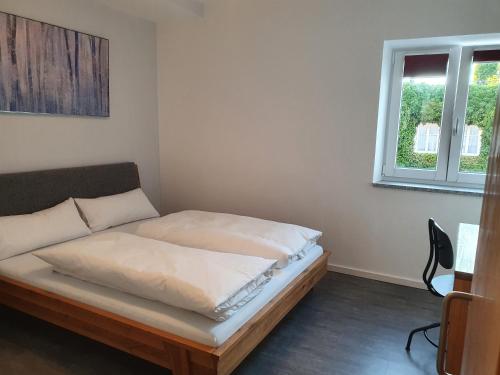 um quarto com uma cama num quarto com uma janela em Pension HopfaHeisl em Wolnzach