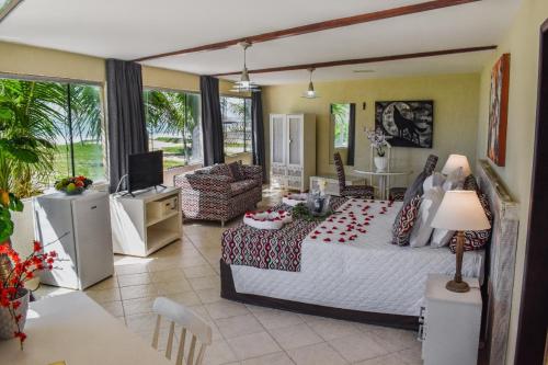a large room with a bed and a living room at Pousada Recanto do Lobo in Porto De Galinhas
