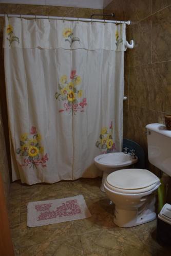 a bathroom with a shower curtain and a toilet at Estancia Santa Leocadia in Bialet Massé