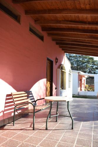 a bench and a table in front of a building at Estancia Santa Leocadia in Bialet Massé