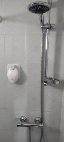 a shower in a bathroom with a shower head at Panorama Oia Apartments in Oia