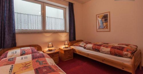 萊斯高山溪谷安格勒的住宿－藍迪豪斯穆勒酒店，带2扇窗户的客房内的2张单人床