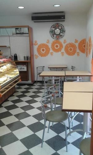 a restaurant with tables and chairs on a checkered floor at B&B Casa Piva in Serravalle