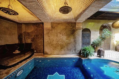 a bath room with a tub and a pool at Riad Zhor in Marrakesh